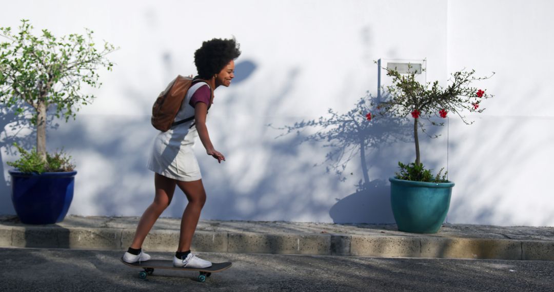 Teen girl skateboarding on city street on a sunny day - Free Images, Stock Photos and Pictures on Pikwizard.com