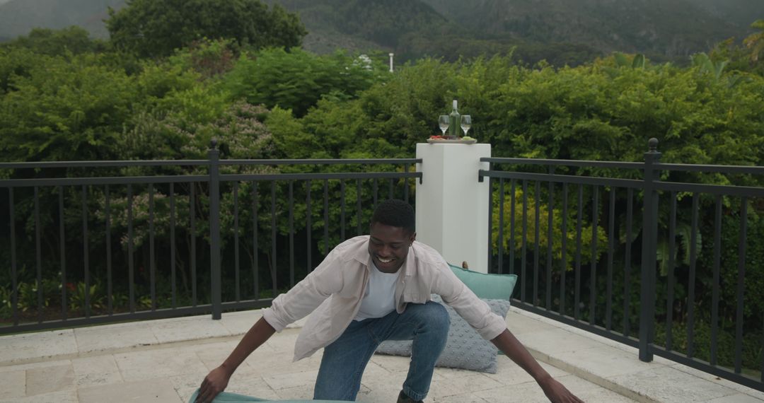 Person Preparing Outdoor Patio for Event with Cushions