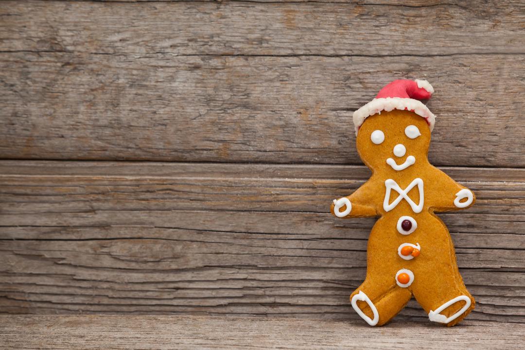 Festive Gingerbread Man with Santa Hat on Wooden Background - Free Images, Stock Photos and Pictures on Pikwizard.com
