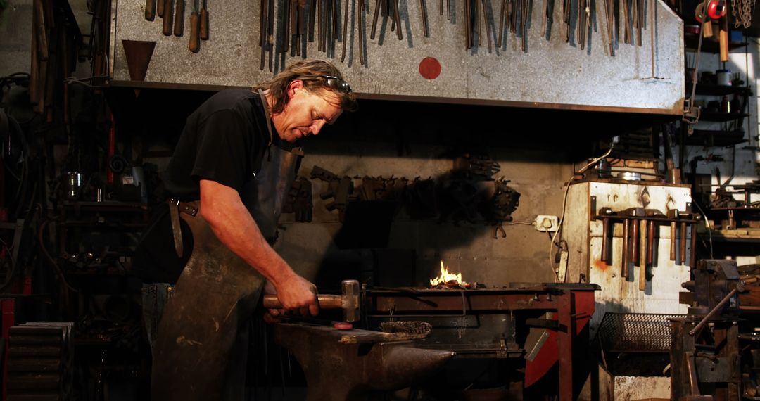 Experienced Blacksmith Forging Iron in Traditional Workshop Setting