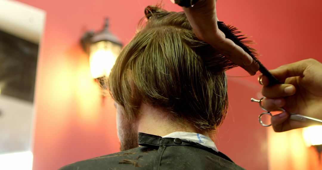 Hairdresser Trimming Client's Hair in Salon with Red Walls - Free Images, Stock Photos and Pictures on Pikwizard.com