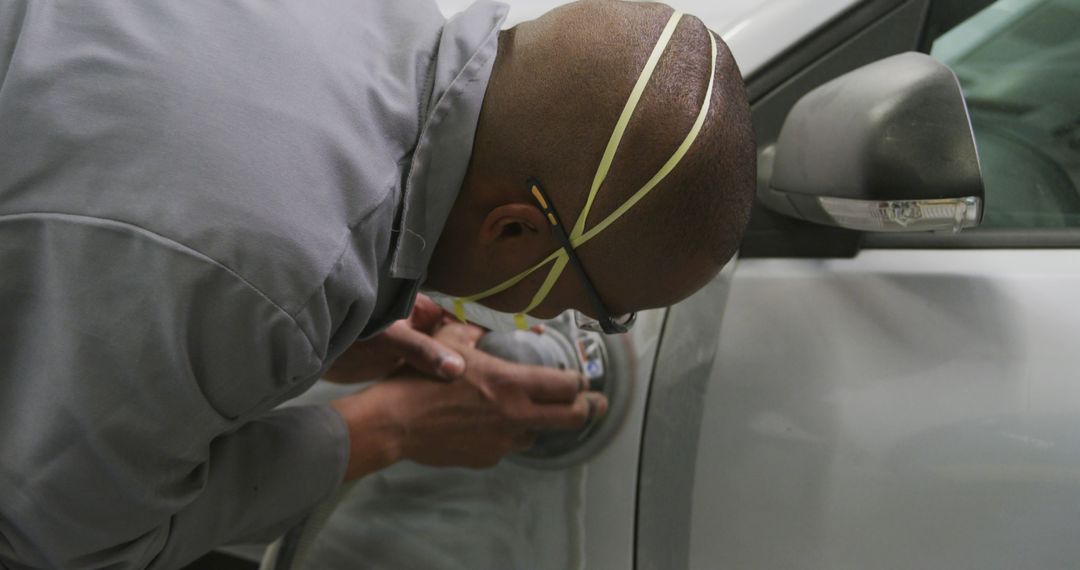 Auto technician buffing car with protective mask - Free Images, Stock Photos and Pictures on Pikwizard.com