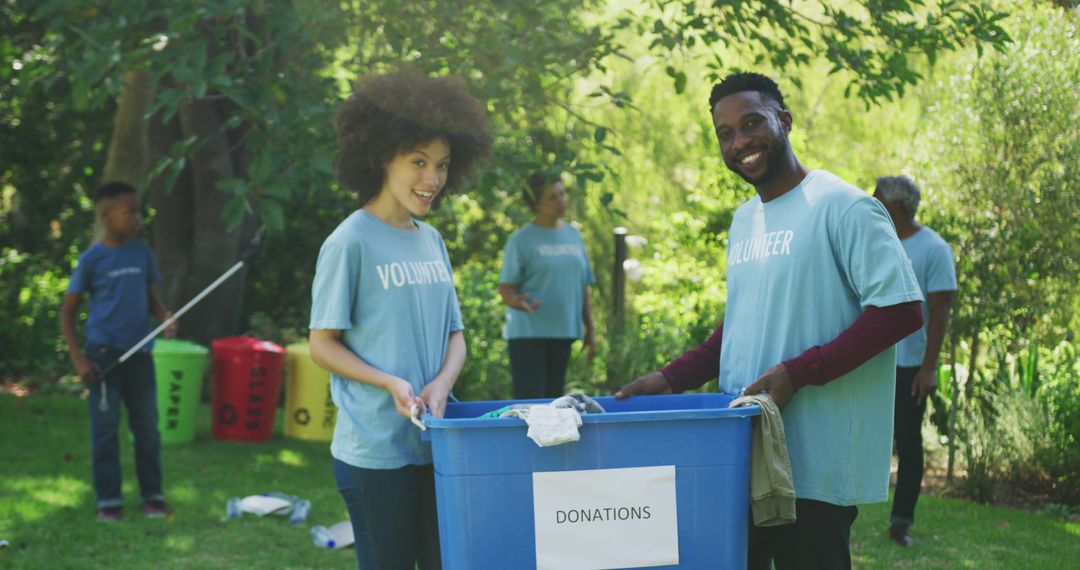 Diverse Volunteers Smiling While Collecting Donations Outdoors - Free Images, Stock Photos and Pictures on Pikwizard.com