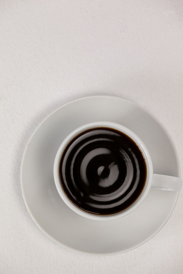 Overhead View of Black Coffee in White Cup on Saucer - Free Images, Stock Photos and Pictures on Pikwizard.com