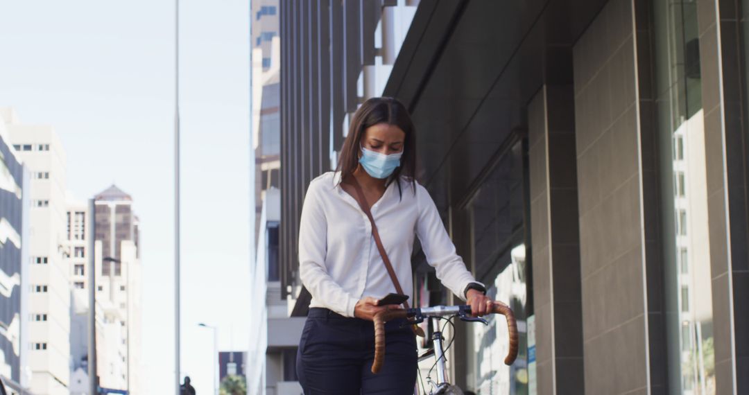 Woman Walking Bicycle on Urban Street Wearing Face Mask - Free Images, Stock Photos and Pictures on Pikwizard.com