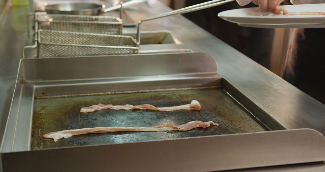 Cooking Bacon on Commercial Griddle in Professional Kitchen - Free Images, Stock Photos and Pictures on Pikwizard.com