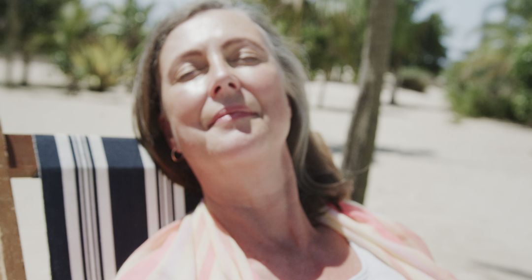 Relaxed senior woman sunbathing on beach chair - Free Images, Stock Photos and Pictures on Pikwizard.com