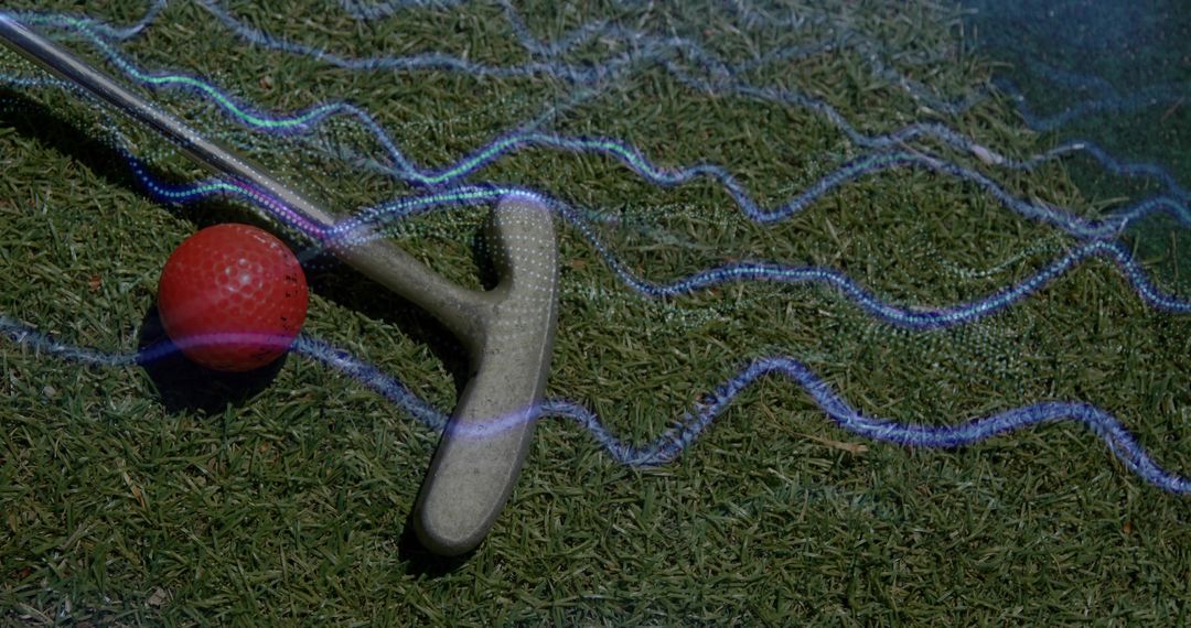 Red dimpled golf ball and putter resting on putting green with neon blue light trails