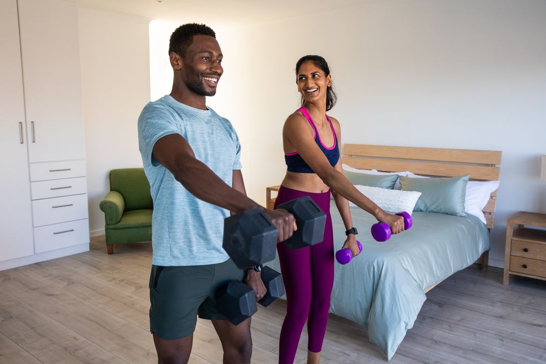 Happy Couple Exercising Together at Home with Dumbbells