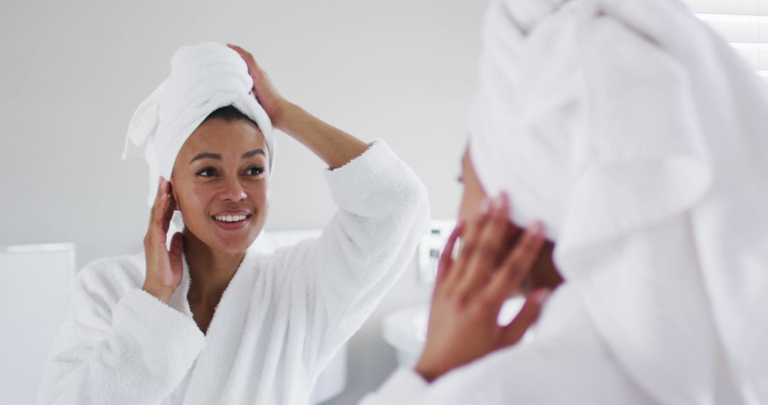 Woman with towel on head examining skin in bathroom mirror - Free Images, Stock Photos and Pictures on Pikwizard.com