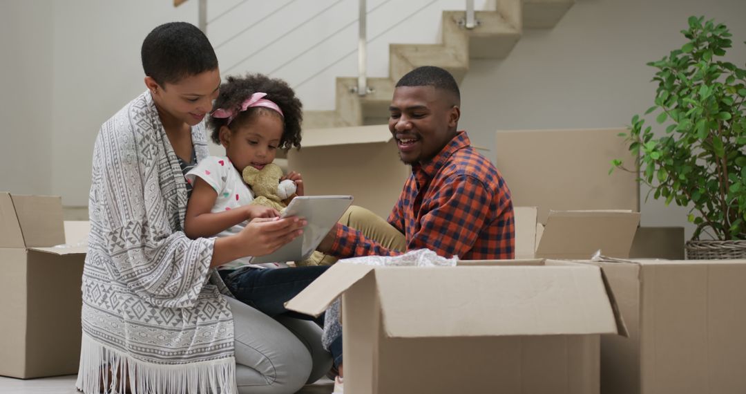 Happy African American Family Using Tablet While Unpacking in New Home - Free Images, Stock Photos and Pictures on Pikwizard.com