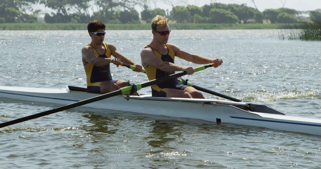 Two Men in Rowing Competition on Sunny Day - Free Images, Stock Photos and Pictures on Pikwizard.com