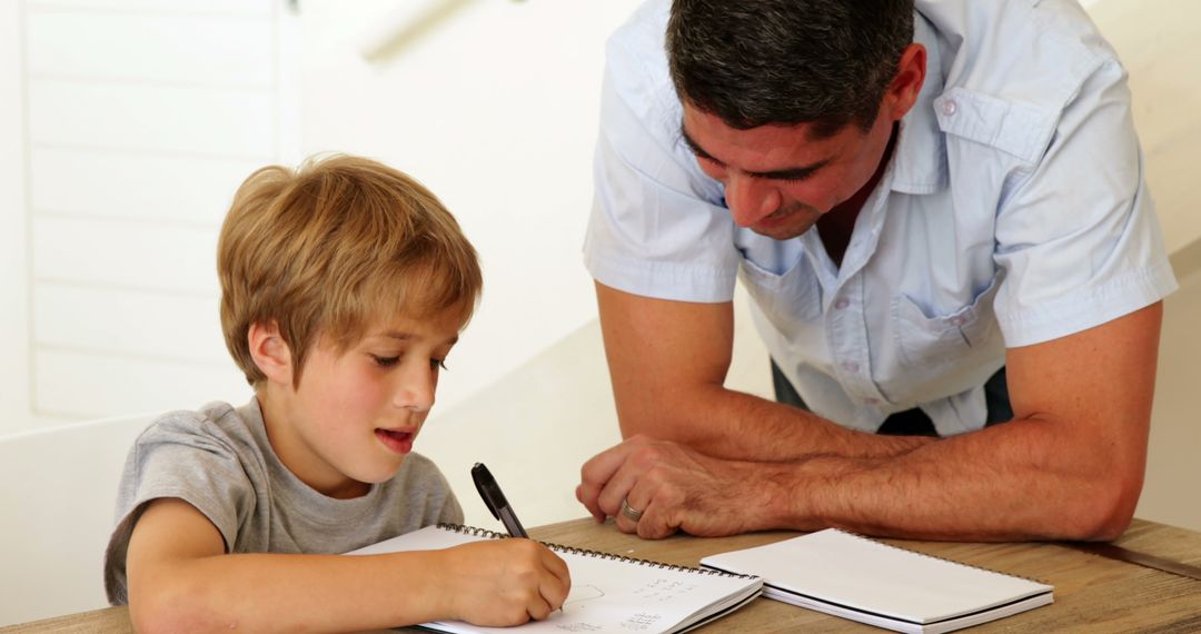 Father Helping Son with Homework at Home in Living Room - Free Images, Stock Photos and Pictures on Pikwizard.com