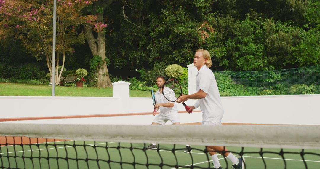 Young Men Playing Doubles Tennis on Outdoor Court - Free Images, Stock Photos and Pictures on Pikwizard.com