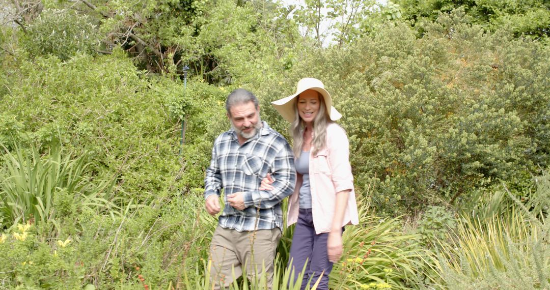 Happy Couple Walking Through Sunny Garden Path in Summer