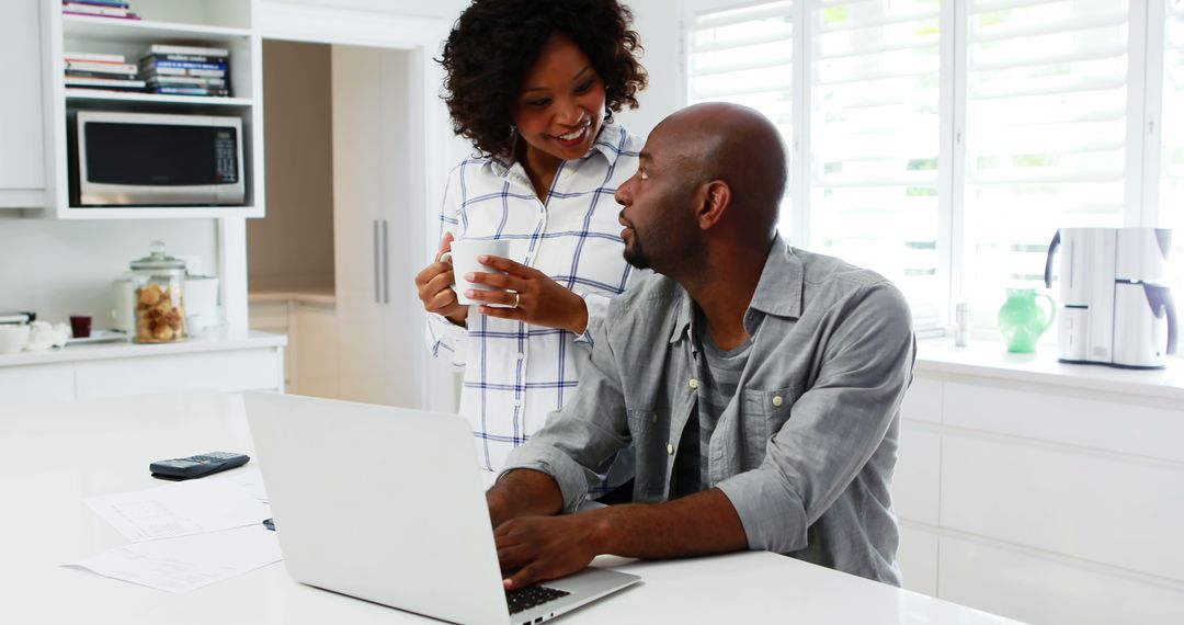 Couple Collaborating in Modern Kitchen Discussing on Laptop