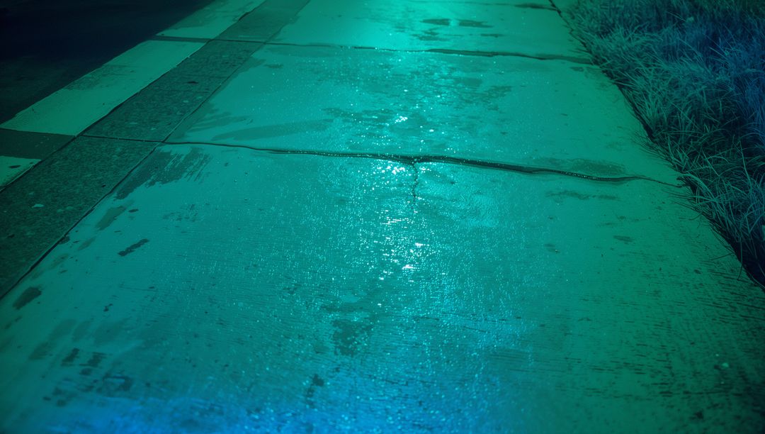 Moody Urban Night Scene with Wet Concrete Sidewalk