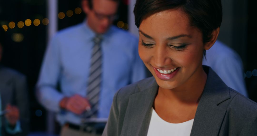 Smiling Businesswoman Looking Down in Office at Night - Free Images, Stock Photos and Pictures on Pikwizard.com