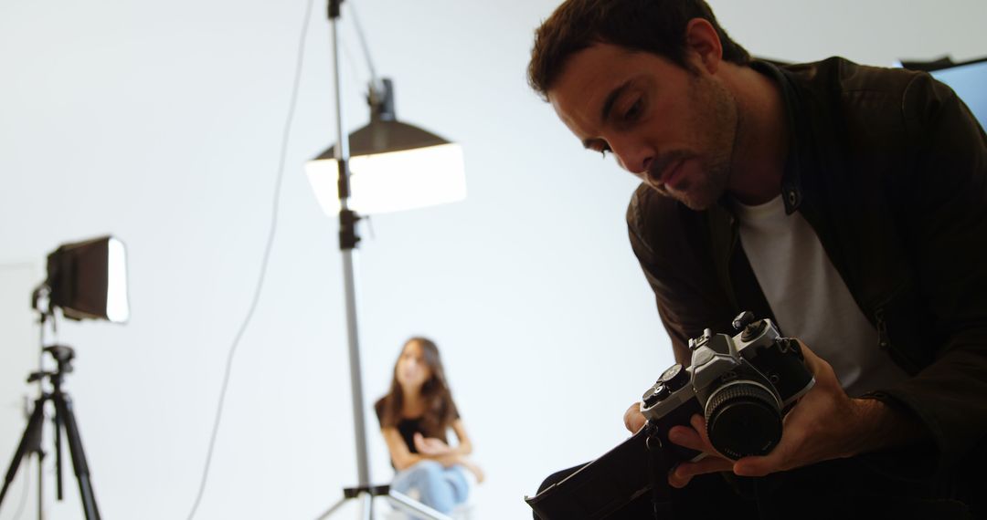 Photographer Setting Up Camera in Studio with Model - Free Images, Stock Photos and Pictures on Pikwizard.com