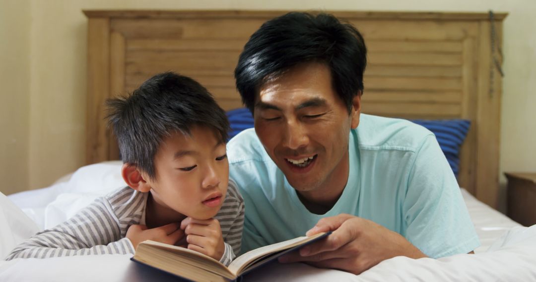 Father and Son Sharing Bedtime Story in Bedroom - Free Images, Stock Photos and Pictures on Pikwizard.com