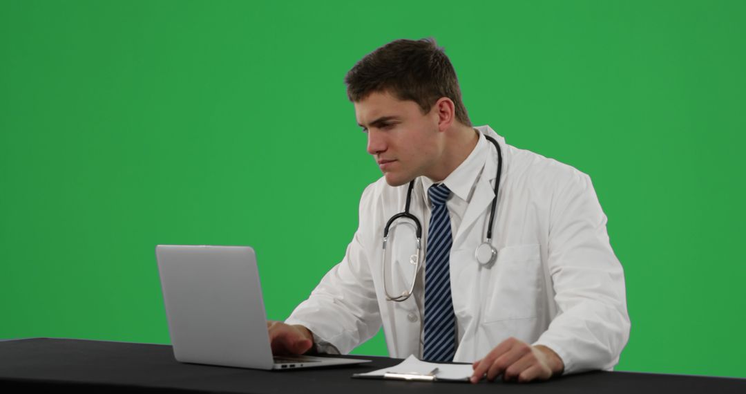 Young Male Doctor Working on Laptop with Green Screen Background - Free Images, Stock Photos and Pictures on Pikwizard.com