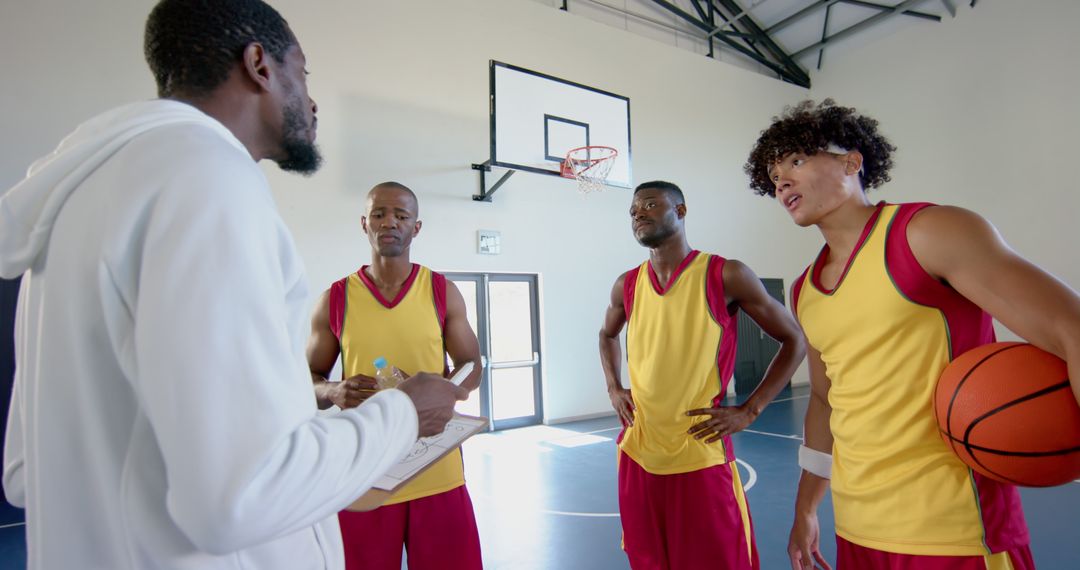 Coach Strategizing with Diverse Basketball Team in Gym