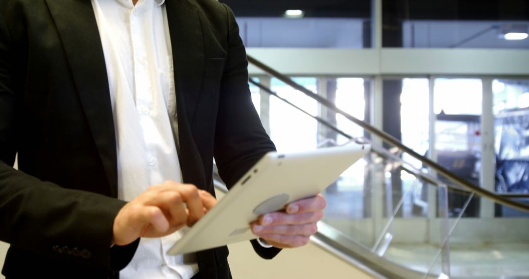 Businessman Using Tablet in Modern Office Building - Free Images, Stock Photos and Pictures on Pikwizard.com