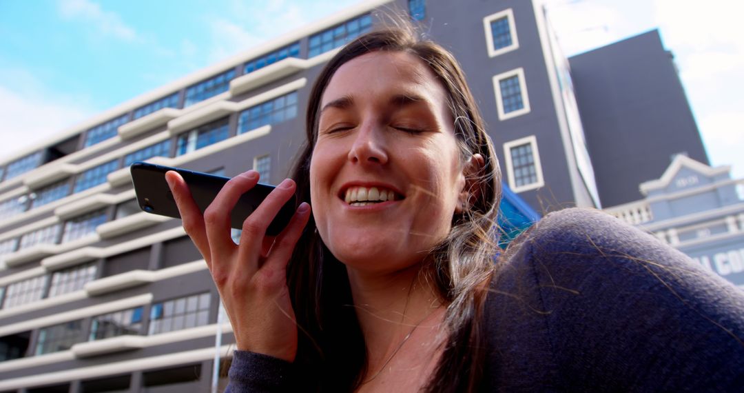 Smiling Woman Using Voice Control on Smartphone in Urban Setting - Free Images, Stock Photos and Pictures on Pikwizard.com