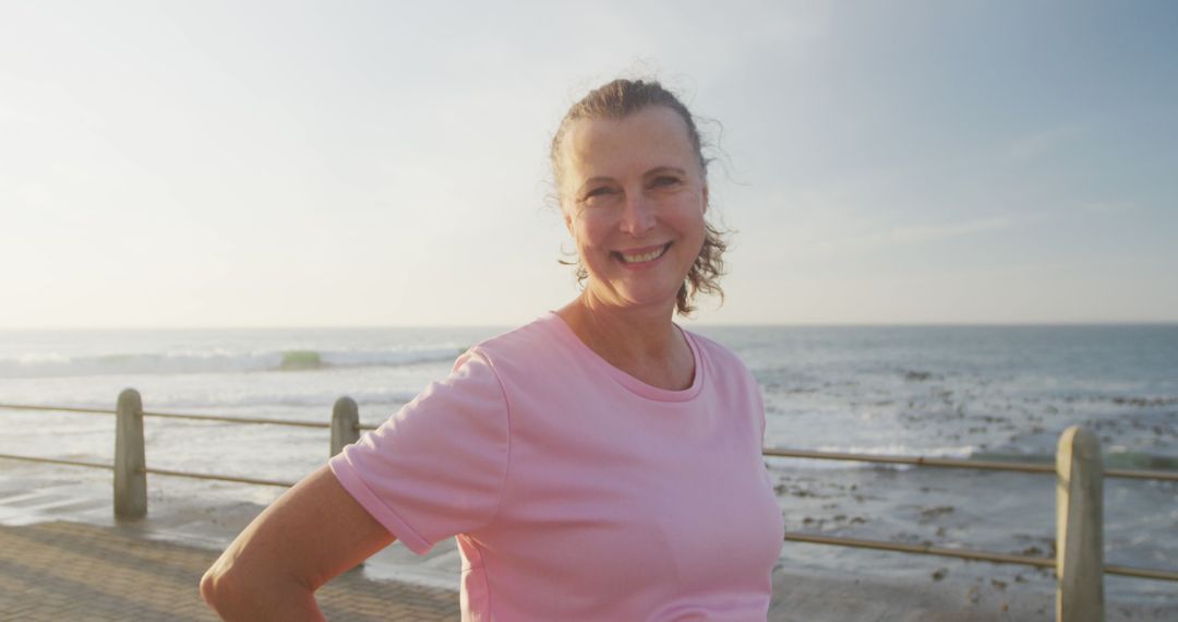 Senior Woman Smiling by the Seaside In Pink T-Shirt During Sunset - Free Images, Stock Photos and Pictures on Pikwizard.com