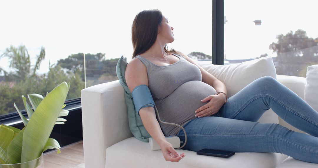 Expectant Mother Relaxing While Monitoring Blood Pressure at Home