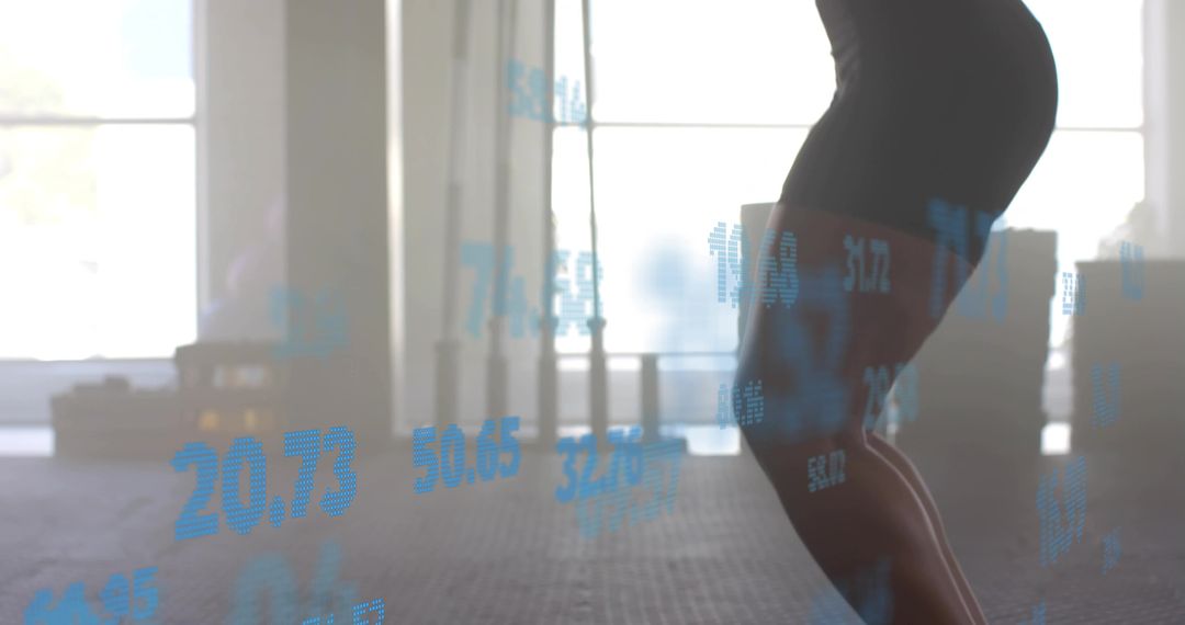 Squatting Athlete Lowering Hips in Gym with Blue Performance Data Overlay and Backlit Silhouette