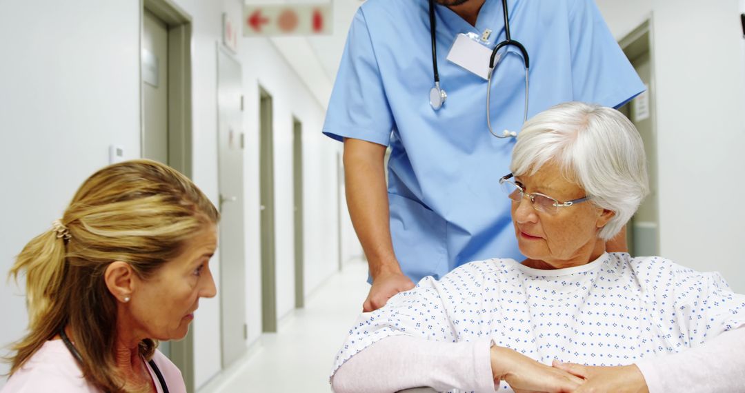 Nurse Assisting Senior Woman in Hospital Hallway with Concerned Family Member - Free Images, Stock Photos and Pictures on Pikwizard.com