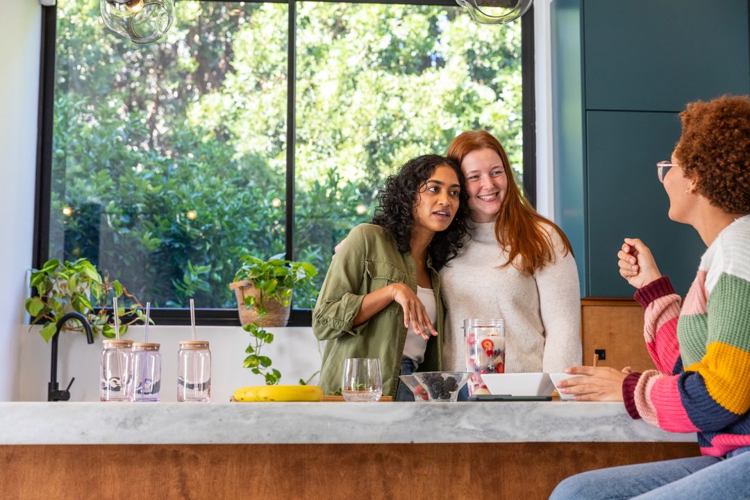 Diverse Female Friends Enjoying Healthy Drinks in Modern Kitchen