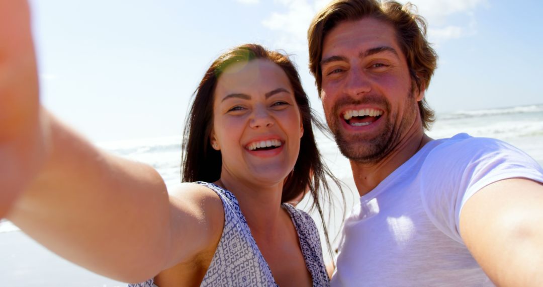 Happy couple smiling and taking selfie on sunny beach - Free Images, Stock Photos and Pictures on Pikwizard.com