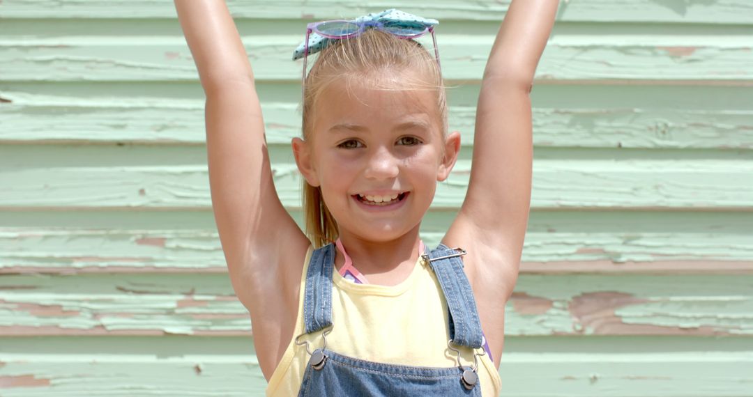 Happy Young Girl Wearing Overalls Posing Against Weathered Wall - Free Images, Stock Photos and Pictures on Pikwizard.com