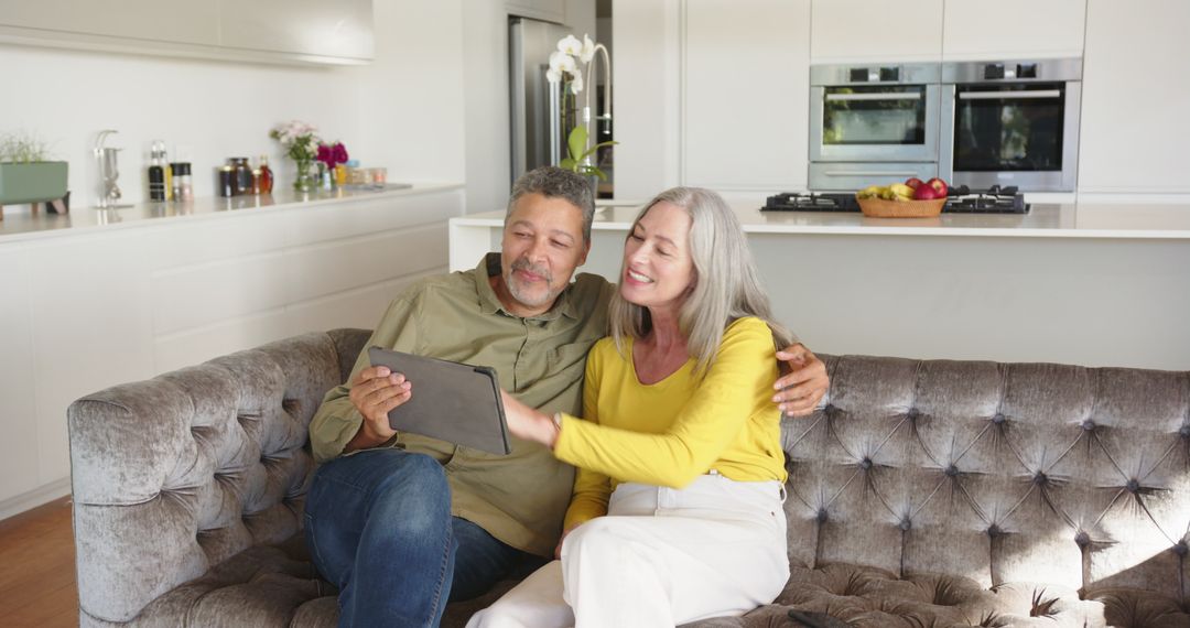 Smiling Mature Couple Using Tablet in Stylish Kitchen Setting