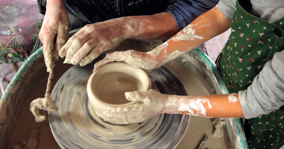 Instructors Hands Guiding Student on Pottery Wheel Creating Clay Pot - Free Images, Stock Photos and Pictures on Pikwizard.com