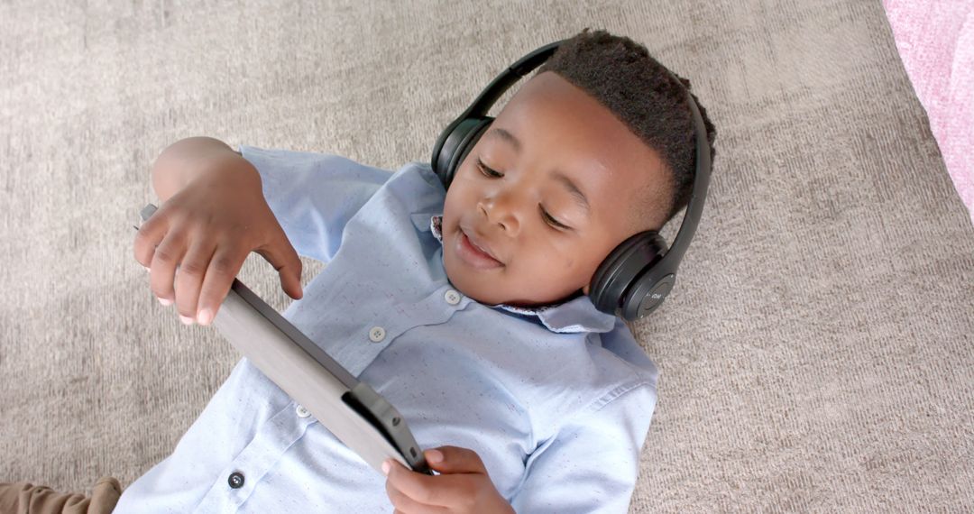 Child Relaxing with Tablet and Headphones on Couch - Free Images, Stock Photos and Pictures on Pikwizard.com