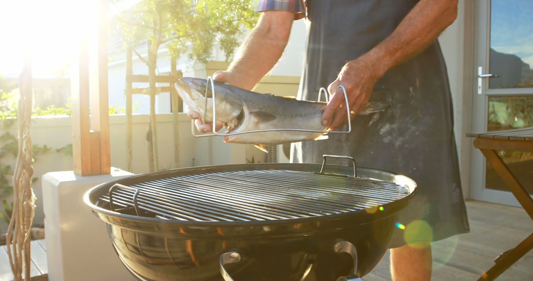 Man Grilling Fish Outdoors on Sunny Day - Free Images, Stock Photos and Pictures on Pikwizard.com