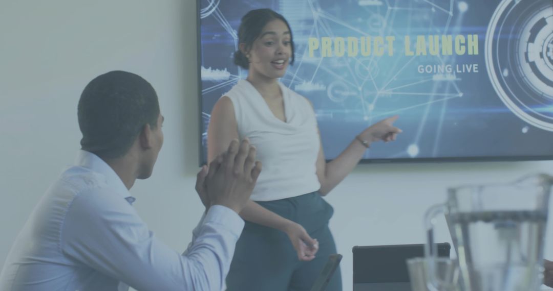 Female Presenter Pointing at Product Launch Screen While Team Applauding in Boardroom
