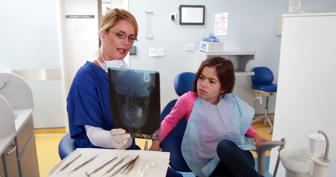 Dentist Explaining X-Ray Image to Concerned Young Girl in Dental Clinic - Free Images, Stock Photos and Pictures on Pikwizard.com