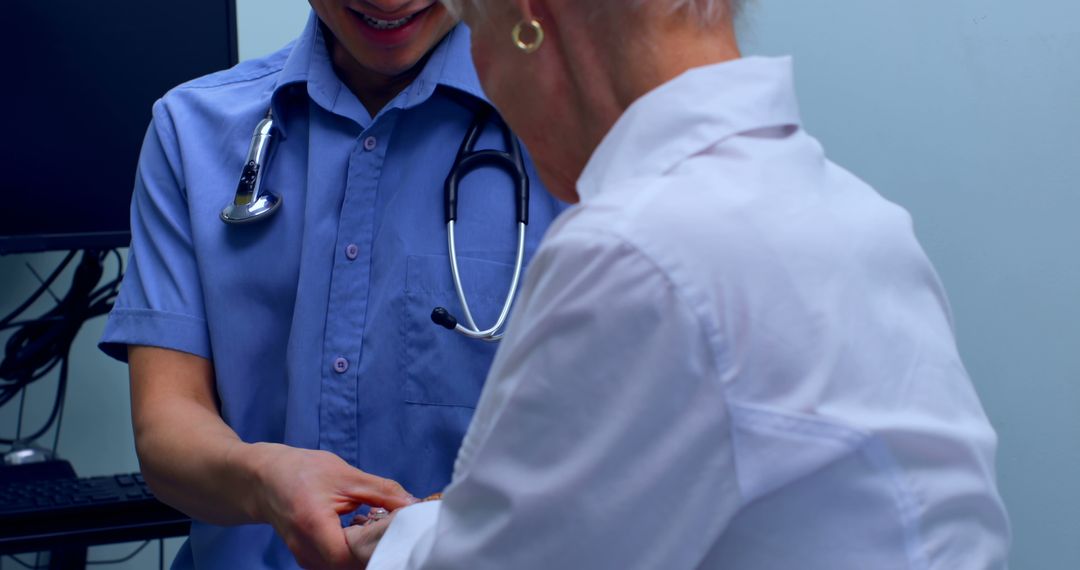 Young Doctor Interacting with Senior Patient in Clinic - Free Images, Stock Photos and Pictures on Pikwizard.com