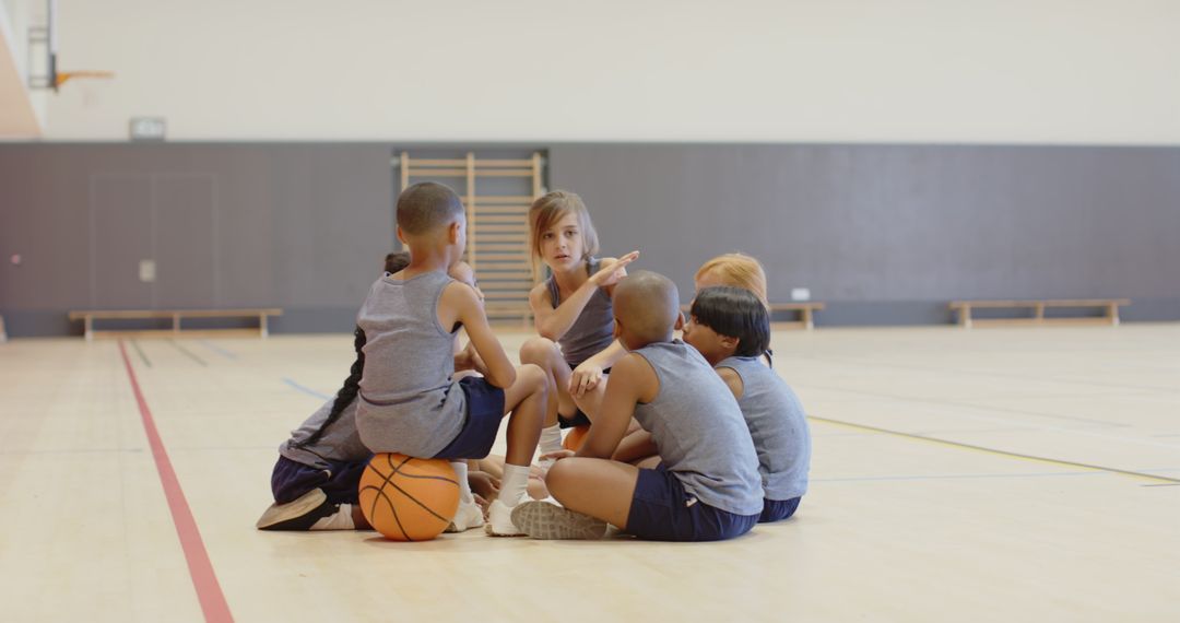 Diverse Children's Basketball Team Collaborating in Gym
