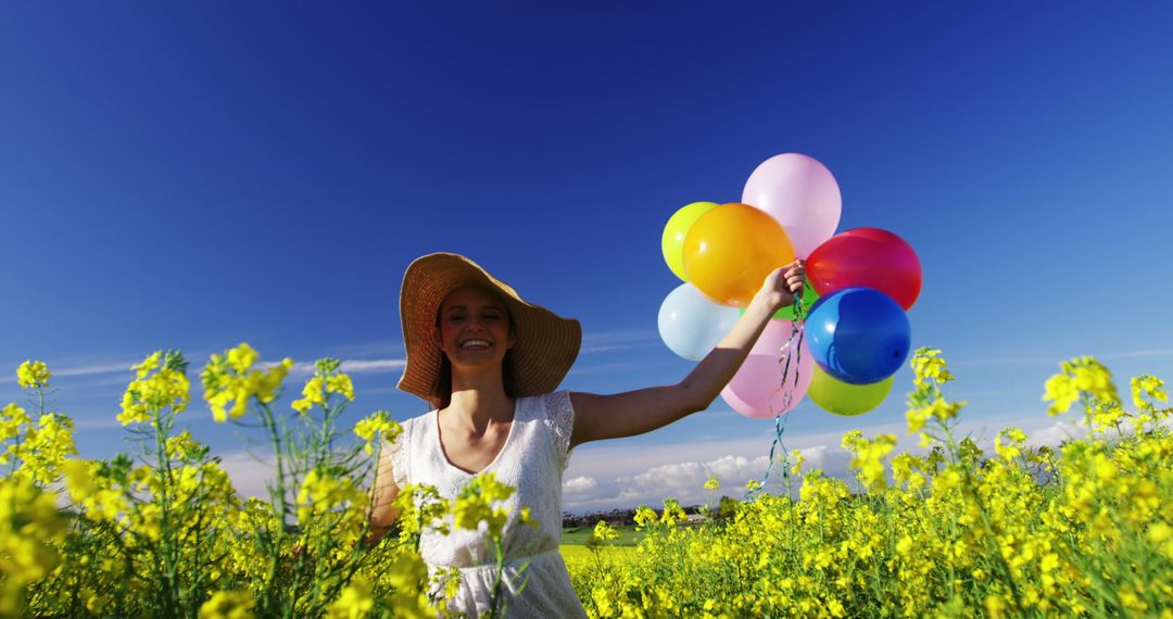 Joyful Woman Walking with Colorful Balloons in Sunny Mustard Field - Free Images, Stock Photos and Pictures on Pikwizard.com