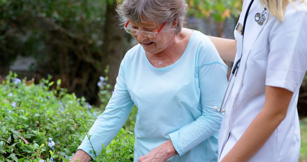 Elderly woman receiving support from caregiver in garden - Free Images, Stock Photos and Pictures on Pikwizard.com