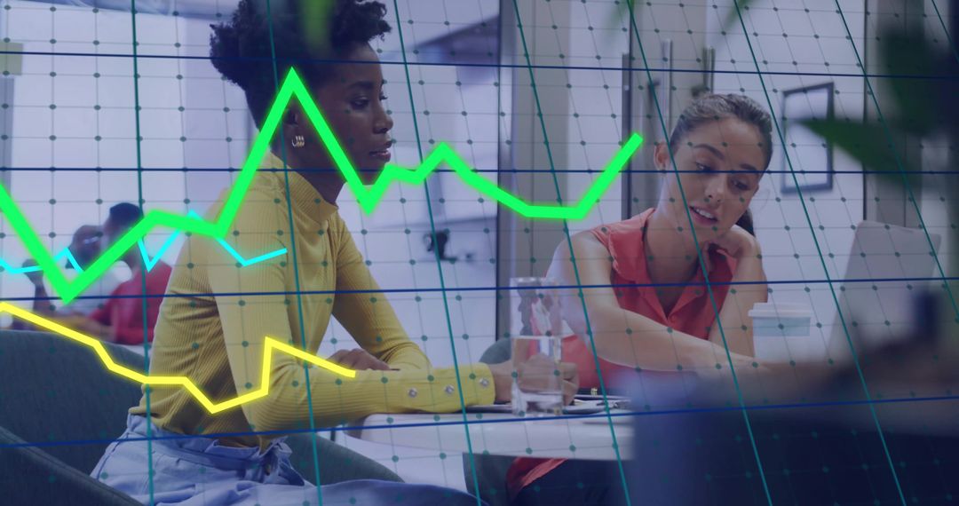 Diverse Businesswomen Reviewing Financial Documents with Data Overlay