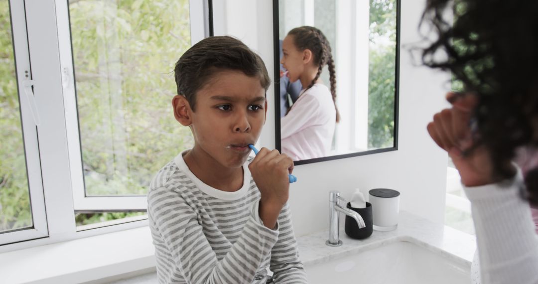 Focused Young Boy Brushing Teeth in Bathroom with Mirror Reflection - Free Images, Stock Photos and Pictures on Pikwizard.com