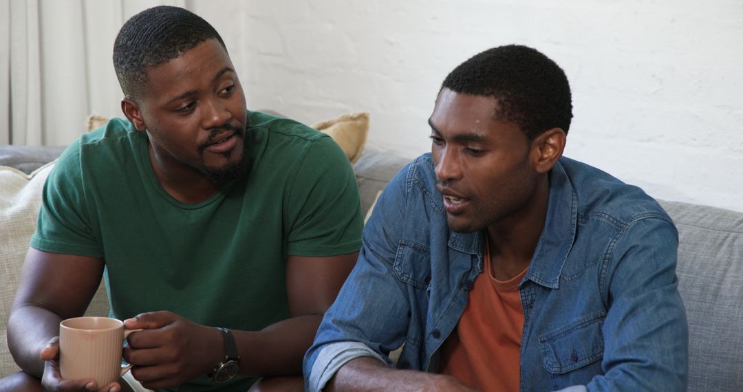 Friends Relaxing and Chatting on Comfortable Sofa