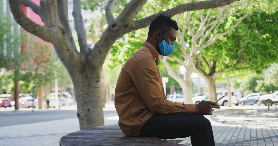 Man Wearing Face Mask While Using Smartphone in Park - Free Images, Stock Photos and Pictures on Pikwizard.com