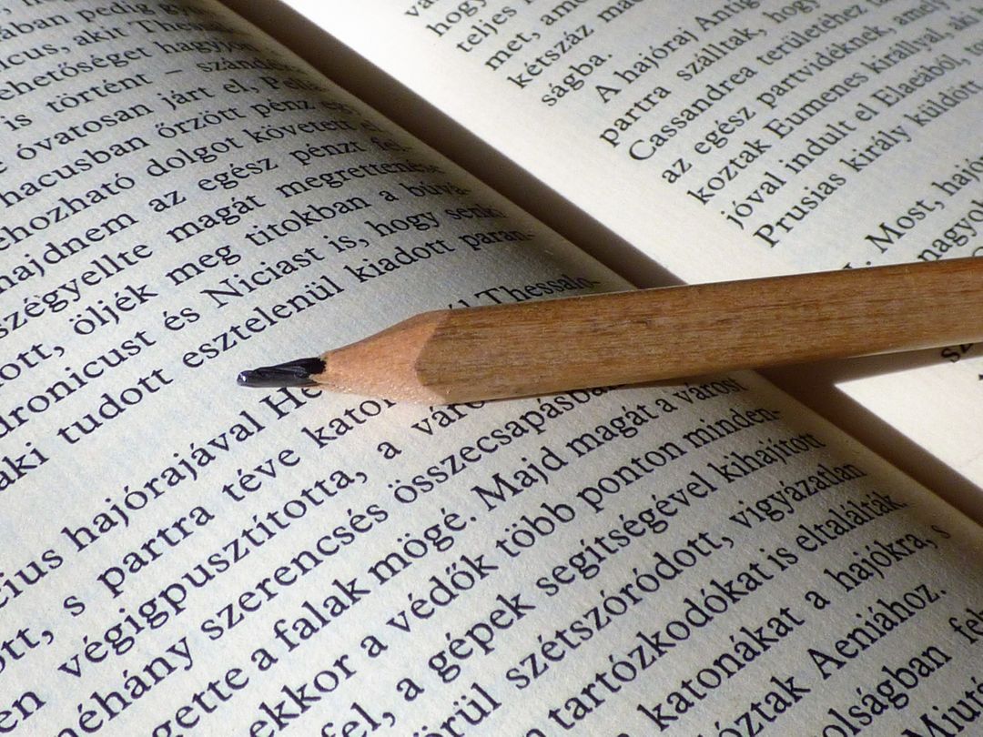 Close-up of Pencil on Open Book with Text - Free Images, Stock Photos and Pictures on Pikwizard.com